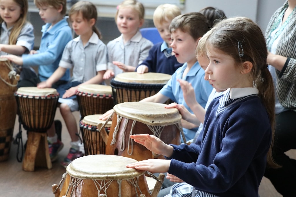 Children playing drums indoors.