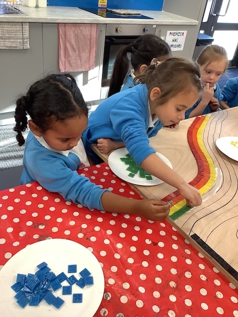 Children placing tiles on table.